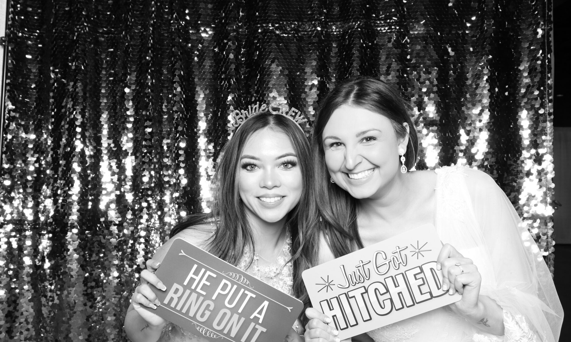 Happy Bride and Friend holding photo booth prop signs